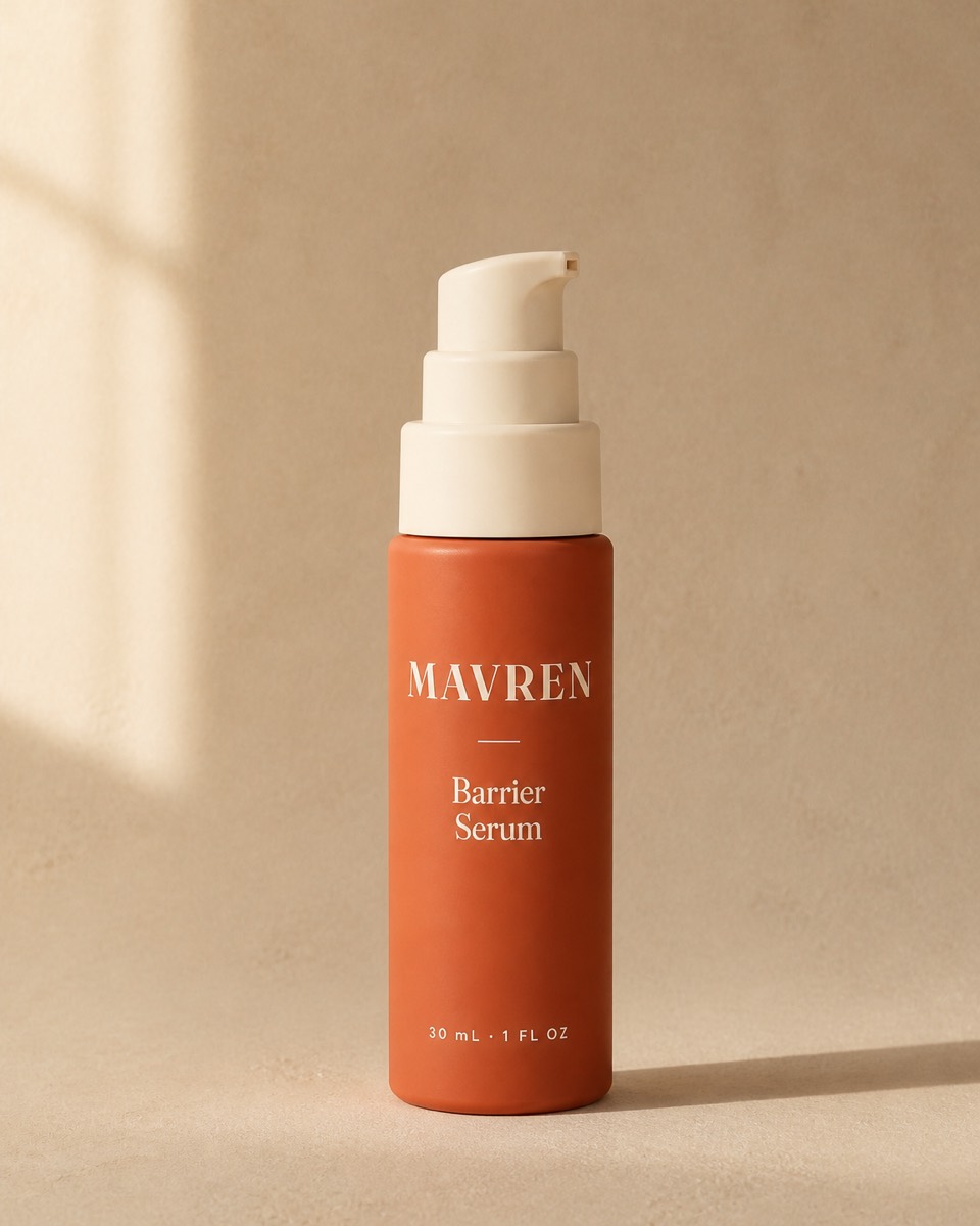A coral serum bottle with a cream pump on a warm stone background